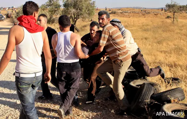 Palestinians run from tear gas fired by Israeli soldiers after two shepherds from the village of Aqraba, south of the city of Nablus in the Israeli occupied West Bank were allegedly attacked by Jewish settlers from the I...