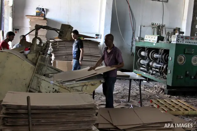 Palestinian labourers work at a factory for making a carton in the West Bank city of Nablus on July 09, 2012. Photo by Nedal Eshtayah