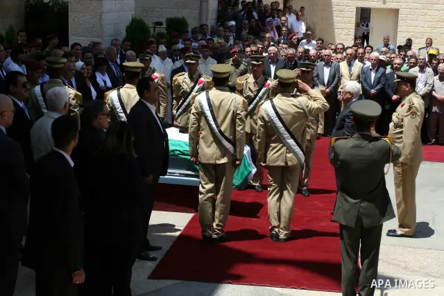 Palestinian President Mahmud Abbas attends the funeral of Hani al-Hassan, who was a close aide of Palestinian late leader, Yasser Arafat, as soldiers carry his coffin during his funeral procession in the West Bank city o...
