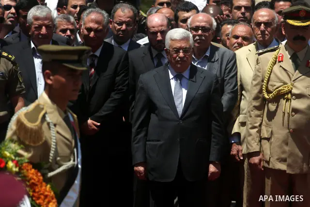 Palestinian President Mahmud Abbas attends the funeral of Hani al-Hassan, who was a close aide of Palestinian late leader, Yasser Arafat, as soldiers carry his coffin during his funeral procession in the West Bank city o...