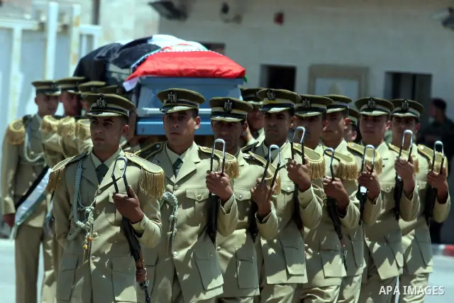 Palestinian soldiers carry the coffin of Hani al-Hassan, who was a close aide to Palestinian late leader, Yasser Arafat, during his funeral procession in the West Bank city of Ramallah on July 9, 2012. Hassan died on Jul...