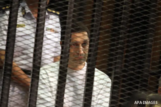 CAIRO, July 9, 2012 Alaa Mubarak, a son of former Egyptian president Hosni Mubarak, are seen behind bars during their trial at the police academy in Cairo, July 9, 2012. Egypt's South Cairo Court on Monday started the tr...