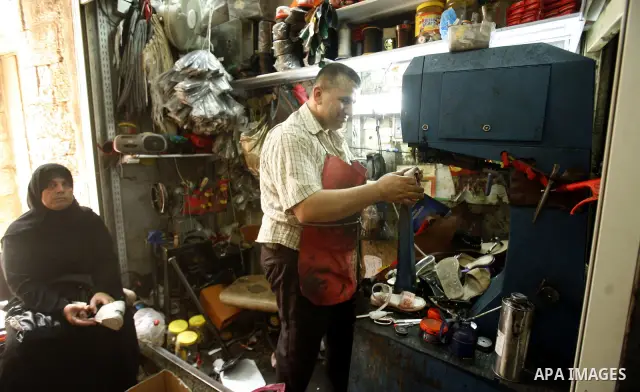 Palestinian shoemaker reforms shoes to a women at the market of Jerusalem's Old City on July 09, 2012. Photo by Mahfouz Abu Turk