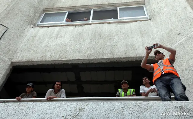 Palestinians look at soccer player Mahmoud Al-Sarsak while he waves to people upon his arrival in Gaza City July 10, 2012. Israel released the Gaza soccer player on Tuesday in a deal to end his intermittent four-month hu...
