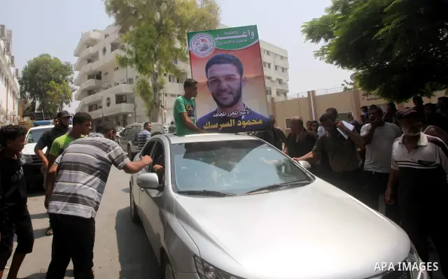 Palestinians hold pictures of Palestinian soccer player Mahmoud Al-Sarsak upon his arrival in Gaza City July 10, 2012. Israel released the Gaza soccer player on Tuesday in a deal to end his intermittent four-month hunger...