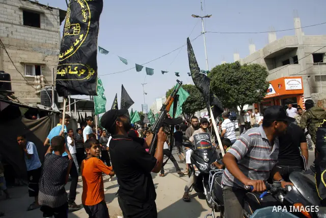 A Palestinian militant fires bullets as Palestinian soccer player Mahmoud Al-Sarsak arrives to Rafah, southern Gaza strip on July 10, 2012 upon his release from Israeli prison. Sarsak staged a hunger strike of nearly thr...