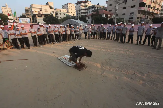 A Palestinian trainer stands on tapered nails during training in a summer camp organized by Hamas movement at Shati refugee camp in Gaza City July 10, 2012. Hamas movement organized dozens of summer camps for Palestinian...