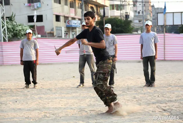 A Palestinian trainer plays martial sport during training in a summer camp organized by Hamas movement at Shati refugee camp in Gaza City July 10, 2012. Hamas movement organized dozens of summer camps for Palestinian chi...