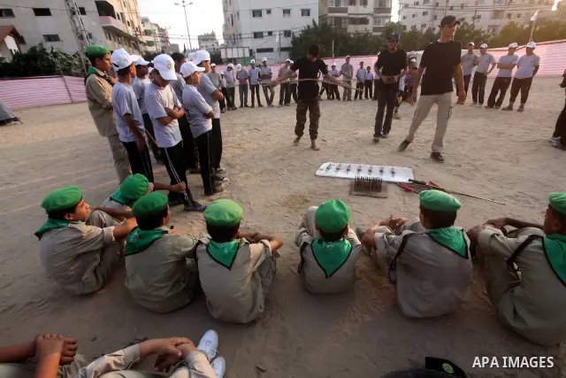 A Palestinian trainer plays martial sport during training in a summer camp organized by Hamas movement at Shati refugee camp in Gaza City July 10, 2012. Hamas movement organized dozens of summer camps for Palestinian chi...