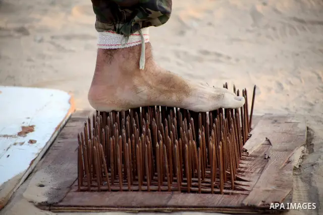 A Palestinian trainer stands on tapered nails during training in a summer camp organized by Hamas movement at Shati refugee camp in Gaza City July 10, 2012. Hamas movement organized dozens of summer camps for Palestinian...
