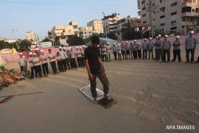 A Palestinian trainer walks on sharp knifes during training in a summer camp organized by Hamas movement at Shati refugee camp in Gaza City July 10, 2012. Hamas movement organized dozens of summer camps for Palestinian c...