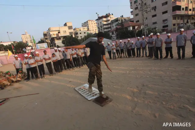 A Palestinian trainer walks on sharp knifes during training in a summer camp organized by Hamas movement at Shati refugee camp in Gaza City July 10, 2012. Hamas movement organized dozens of summer camps for Palestinian c...