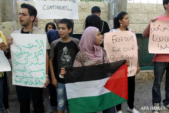 Palestinian protestors hold pictures of Palestinian prisoners in Israeli jails whose are still refusing food for after a deal was made to end a mass prisoner hunger strike, during a demonstration in their support, in the...