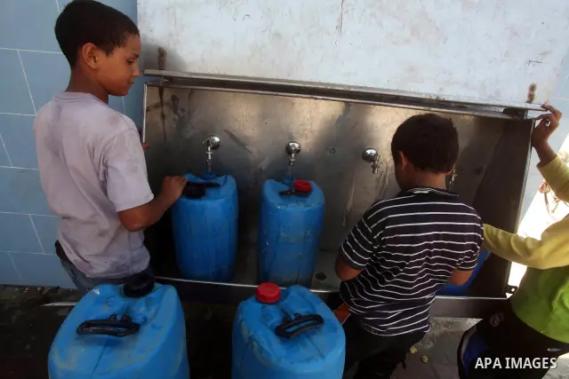 Palestinian children fill their bottles a potable water at a water purification station, in Deir al-Balah central Gaza Strip, on July 11. 2012. Palestinians suffer from the severe lack of potable water. Photo by Ashraf A...