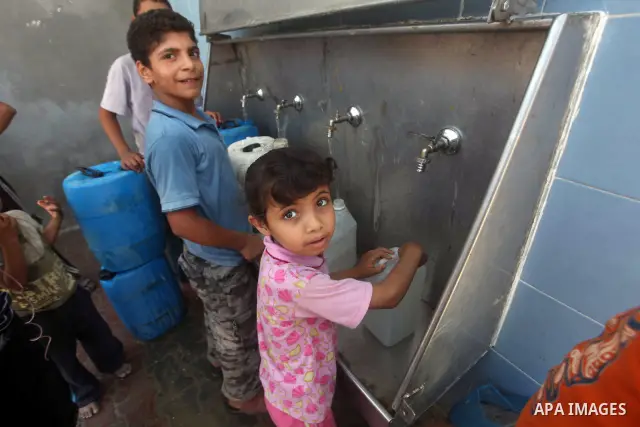Palestinian children fill their bottles a potable water at a water purification station, in Deir al-Balah central Gaza Strip, on July 11. 2012. Palestinians suffer from the severe lack of potable water. Photo by Ashraf A...
