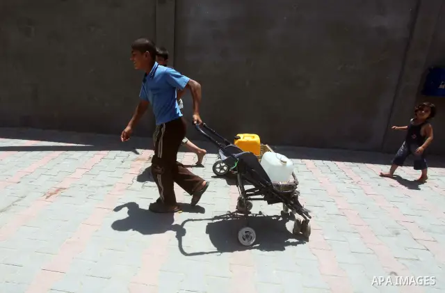 A Palestinian child tows his bottles a potable water by a wagon from a water purification station, in Deir al-Balah central Gaza Strip, on July 11. 2012. Palestinians suffer from the severe lack of potable water. Photo b...