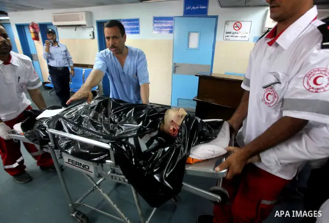 Palestinian medics wheel a Hamas militant into al-Shifa Hospital following an Israeli attack in Gaza City on July 12, 2012. A Palestinian militant from the ruling Hamas movement was killed and two others wounded on Thurs...