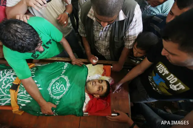 Palestinians mourn over the body of Hamas militant Mahmud Al-Heggi during his funeral in the Al Zaitun area in the east of Gaza city, 12 July 2012. Al Heggi was killed and others wounded after an Israeli air strike in AL...