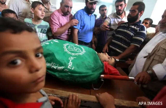 Palestinians mourn over the body of Hamas militant Mahmud Al-Heggi during his funeral in the Al Zaitun area in the east of Gaza city, 12 July 2012. Al Heggi was killed and others wounded after an Israeli air strike in AL...