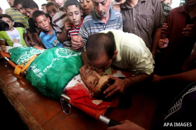 Palestinians mourn over the body of Hamas militant Mahmud Al-Heggi during his funeral in the Al Zaitun area in the east of Gaza city, 12 July 2012. Al Heggi was killed and others wounded after an Israeli air strike in AL...