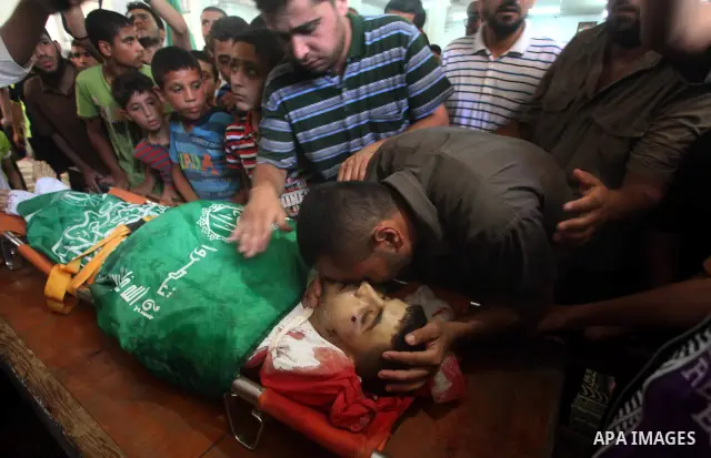Palestinians mourn over the body of Hamas militant Mahmud Al-Heggi during his funeral in the Al Zaitun area in the east of Gaza city, 12 July 2012. Al Heggi was killed and others wounded after an Israeli air strike in AL...