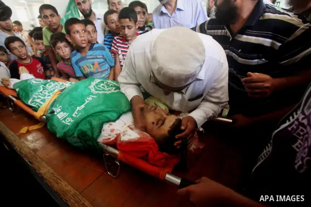 Palestinians mourn over the body of Hamas militant Mahmud Al-Heggi during his funeral in the Al Zaitun area in the east of Gaza city, 12 July 2012. Al Heggi was killed and others wounded after an Israeli air strike in AL...