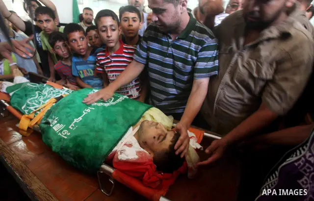 Palestinians mourn over the body of Hamas militant Mahmud Al-Heggi during his funeral in the Al Zaitun area in the east of Gaza city, 12 July 2012. Al Heggi was killed and others wounded after an Israeli air strike in AL...