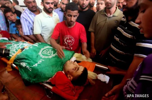 Palestinians mourn over the body of Hamas militant Mahmud Al-Heggi during his funeral in the Al Zaitun area in the east of Gaza city, 12 July 2012. Al Heggi was killed and others wounded after an Israeli air strike in AL...