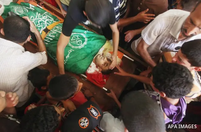 Palestinians mourn over the body of Hamas militant Mahmud Al-Heggi during his funeral in the Al Zaitun area in the east of Gaza city, 12 July 2012. Al Heggi was killed and others wounded after an Israeli air strike in AL...