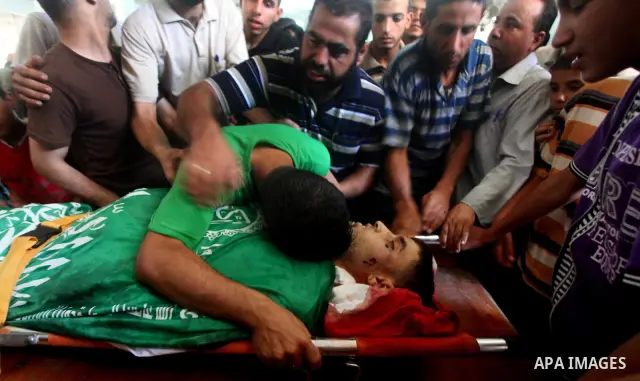 Palestinians mourn over the body of Hamas militant Mahmud Al-Heggi during his funeral in the Al Zaitun area in the east of Gaza city, 12 July 2012. Al Heggi was killed and others wounded after an Israeli air strike in AL...