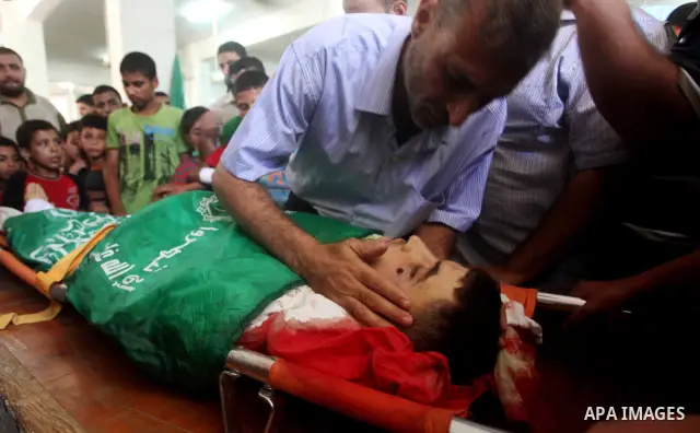 Palestinians mourn over the body of Hamas militant Mahmud Al-Heggi during his funeral in the Al Zaitun area in the east of Gaza city, 12 July 2012. Al Heggi was killed and others wounded after an Israeli air strike in AL...