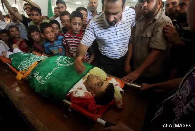 Palestinians mourn over the body of Hamas militant Mahmud Al-Heggi during his funeral in the Al Zaitun area in the east of Gaza city, 12 July 2012. Al Heggi was killed and others wounded after an Israeli air strike in AL...