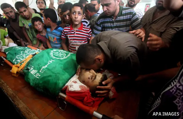 Palestinians mourn over the body of Hamas militant Mahmud Al-Heggi during his funeral in the Al Zaitun area in the east of Gaza city, 12 July 2012. Al Heggi was killed and others wounded after an Israeli air strike in AL...