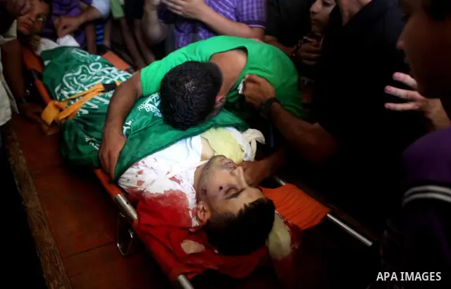 Palestinians mourn over the body of Hamas militant Mahmud Al-Heggi during his funeral in the Al Zaitun area in the east of Gaza city, 12 July 2012. Al Heggi was killed and others wounded after an Israeli air strike in AL...