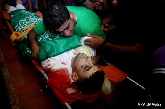 Palestinians mourn over the body of Hamas militant Mahmud Al-Heggi during his funeral in the Al Zaitun area in the east of Gaza city, 12 July 2012. Al Heggi was killed and others wounded after an Israeli air strike in AL...