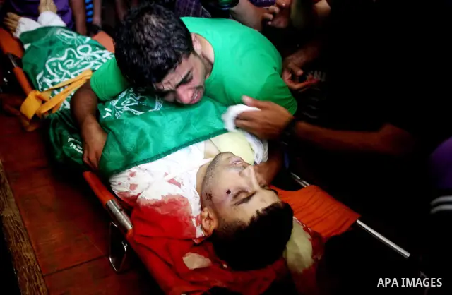 Palestinians mourn over the body of Hamas militant Mahmud Al-Heggi during his funeral in the Al Zaitun area in the east of Gaza city, 12 July 2012. Al Heggi was killed and others wounded after an Israeli air strike in AL...