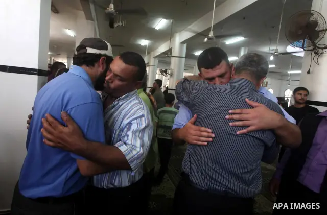 Palestinians mourn over the body of Hamas militant Mahmud Al-Heggi during his funeral in the Al Zaitun area in the east of Gaza city, 12 July 2012. Al Heggi was killed and others wounded after an Israeli air strike in AL...