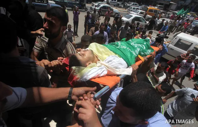 Palestinian mourners carry the body of Hamas militant Mahmud Al-Heggi during his funeral in the Al Zaitun area in the east of Gaza city, 12 July 2012. Al Heggi was killed and others wounded after an Israeli air strike in...