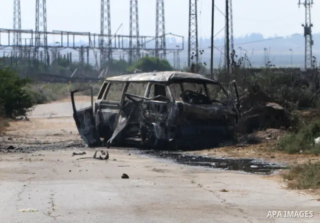 Palestinians inspect a destroyed vehicle following an Israeli bombing in Gaza City on July 12, 2012. A Palestinian was killed and others wounded after an Israeli air strike in al-Zeitoun area in the east of Gaza city on...