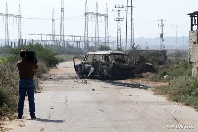 Palestinians inspect a destroyed vehicle following an Israeli bombing in Gaza City on July 12, 2012. A Palestinian was killed and others wounded after an Israeli air strike in al-Zeitoun area in the east of Gaza city on...