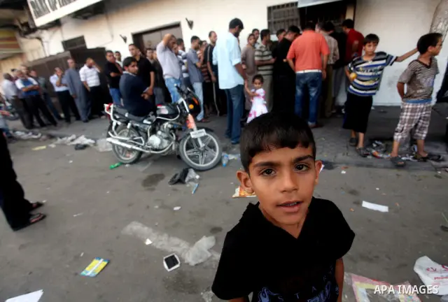 Palestinians queue to draw money from an automated teller machine of the Bank of Palestine in Gaza city on July 12, 2012. The Palestinian Authority announced that it will give only 60% of the salary due to the unpreceden...