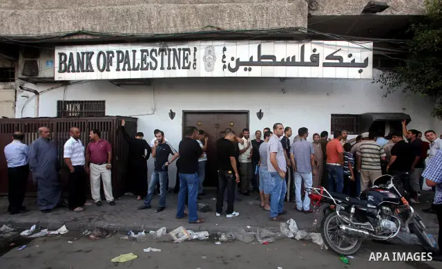 Palestinians queue to draw money from an automated teller machine of the Bank of Palestine in Gaza city on July 12, 2012. The Palestinian Authority announced that it will give only 60% of the salary due to the unpreceden...