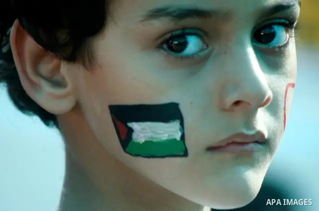 A Palestinian child paints a national flag on his face during a rally on 13 July, 2012 in the east Jerusalem neighborhood of Silwan against Jewish settlement and the judaization in Palestinian districts of the holy city....