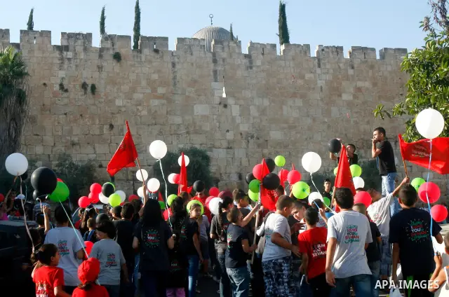 Palestinian children hold balloons and placards during a rally on 13 July, 2012 in the east Jerusalem neighborhood of Silwan against Jewish settlement and the judaization in Palestinian districts of the holy city. Photo...