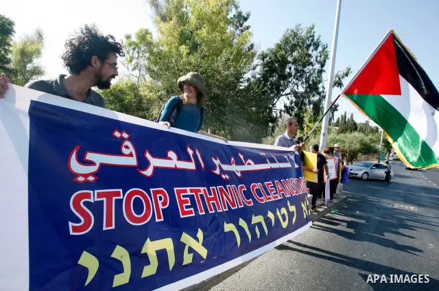 Activists hold signs asking for justice for the residents of Sheikh Jarrah on 13 July, 2012. Foreign activists, Israeli activists and Palestinians participate in the weekly march with the people of the Sheikh Jarrah neig...
