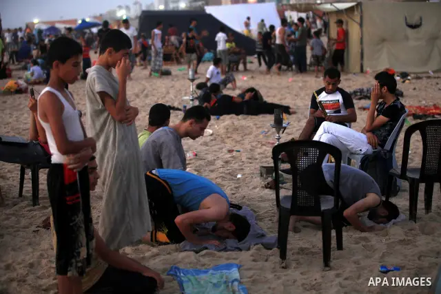 Palestinians pray at Gaza beach during a hot day, on 13 July 2012 in Gaza City. Photo by Majdi Fathi