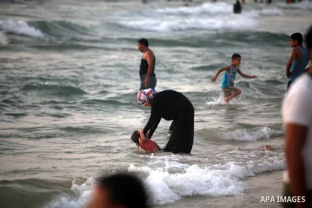 Palestinians enjoy swimming in the sea at Gaza beach on 13 July 2012 in Gaza City. Photo by Majdi Fathi