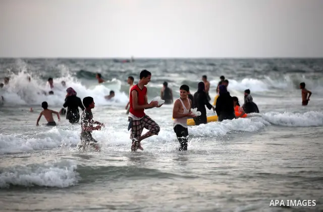 Palestinians enjoy swimming in the sea at Gaza beach on 13 July 2012 in Gaza City. Photo by Majdi Fathi