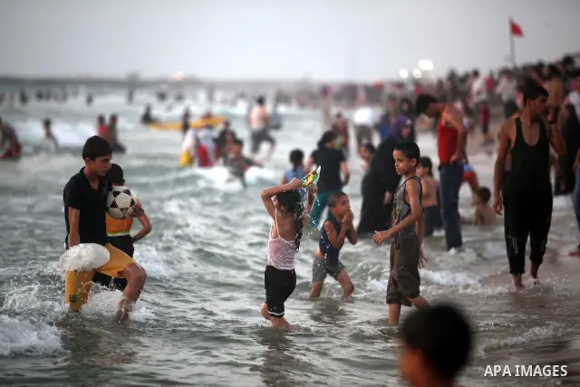 Palestinians enjoy swimming in the sea at Gaza beach on 13 July 2012 in Gaza City. Photo by Majdi Fathi