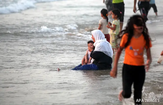 Palestinians enjoy swimming in the sea at Gaza beach on 13 July 2012 in Gaza City. Photo by Majdi Fathi